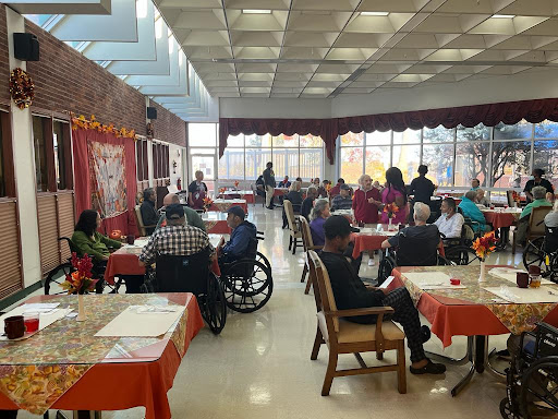A lively community dining area filled with elderly individuals enjoying their time together.