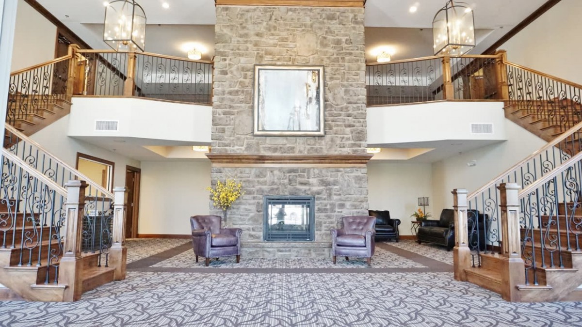 A spacious and elegant lobby with a central stone fireplace, surrounded by comfortable seating areas and tasteful decor.