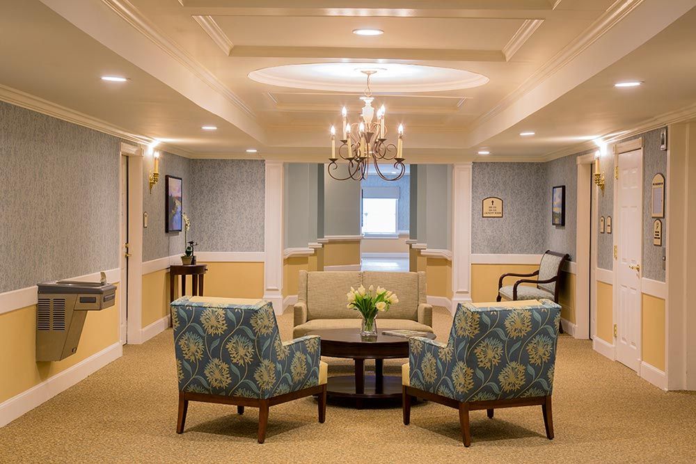 An elegant lobby with comfortable seating and a central chandelier.