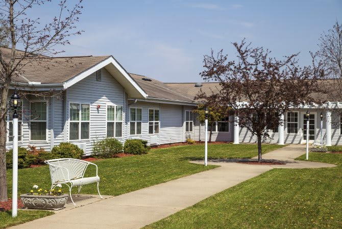 A single-story residential building with a well-maintained lawn and pathway.