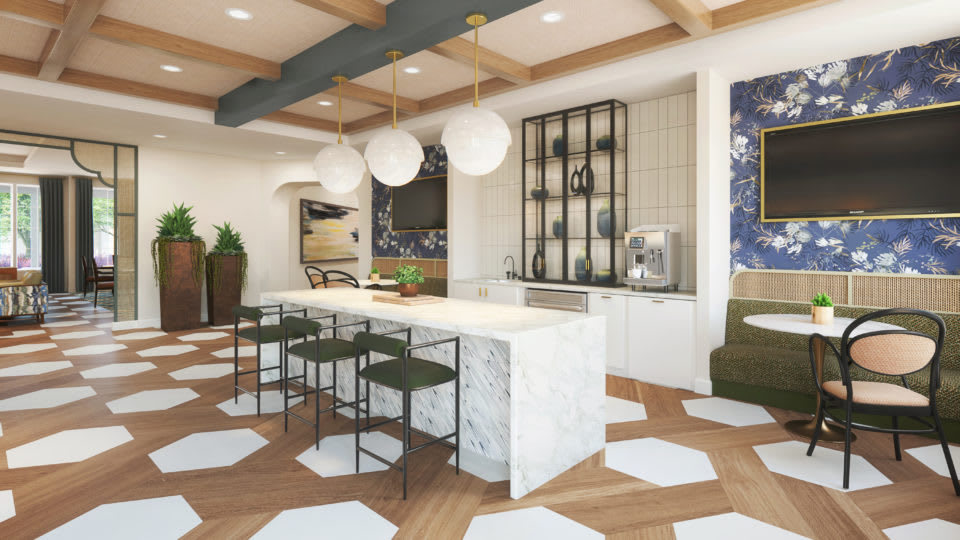 A modern kitchen featuring a central island with sleek bar stools, pendant lighting, and stylish cabinetry in an open and contemporary space.