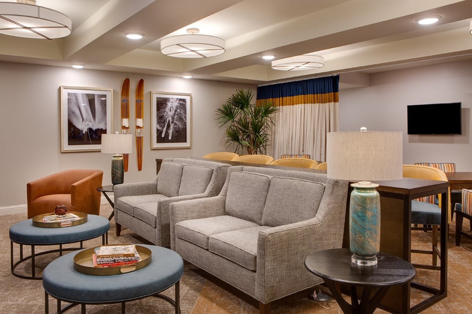 A modern living room with gray sofas, stylish decor, and warm lighting.