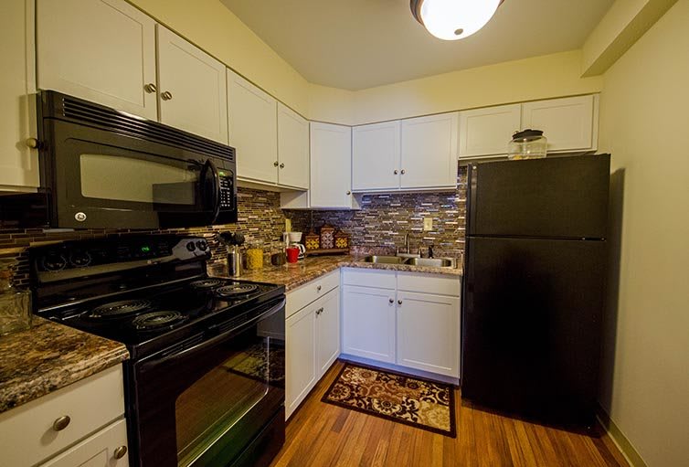 A modern kitchen with black appliances and white cabinetry.