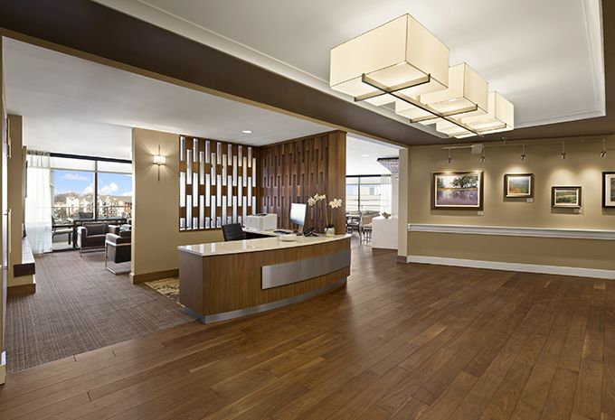 A modern reception area with a wooden desk and elegant lighting.