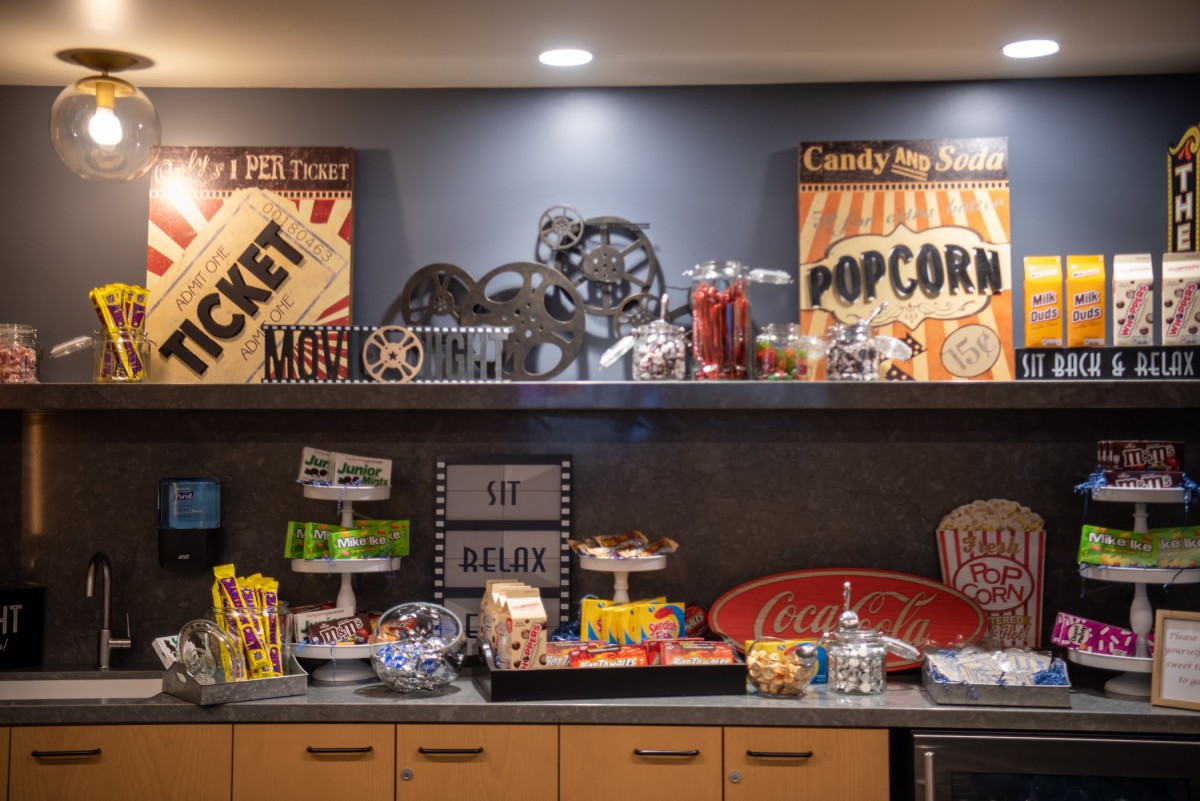 A vintage-style concession stand offering a variety of snacks and drinks, including popcorn, candy, and soda.