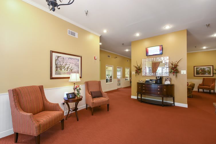 A warmly decorated hallway with comfortable seating and artwork on the walls.