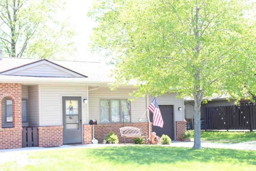 A suburban house with a front yard and an American flag displayed outside.