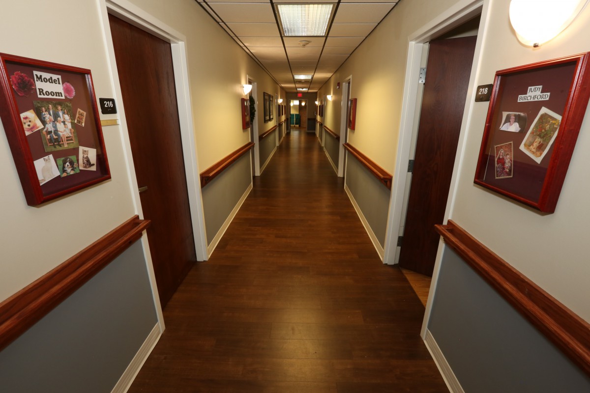A long, well-lit hallway with doors on both sides.