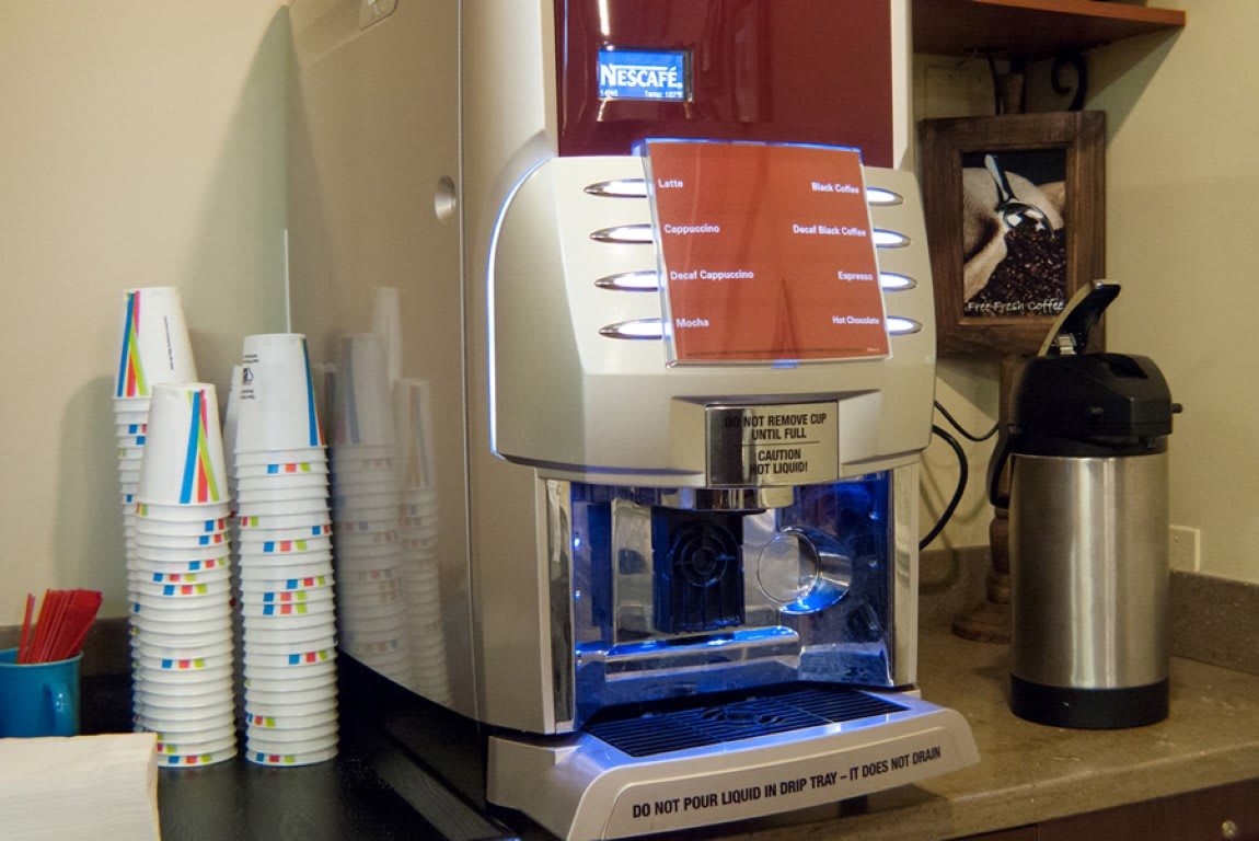A modern coffee and beverage dispenser in an office setting.