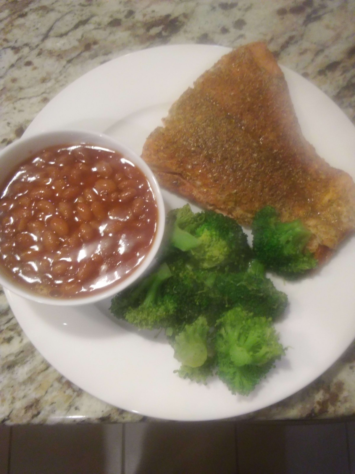 A nutritious meal featuring beans, broccoli, and a breaded fried item on a white plate.