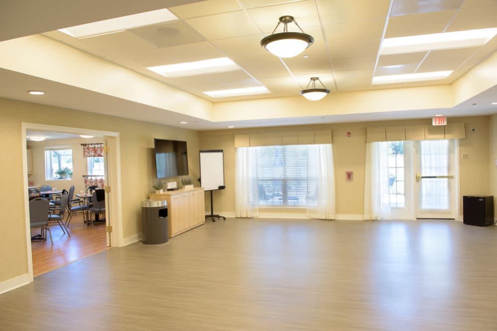 A spacious and well-lit conference room featuring modern decor and large windows.