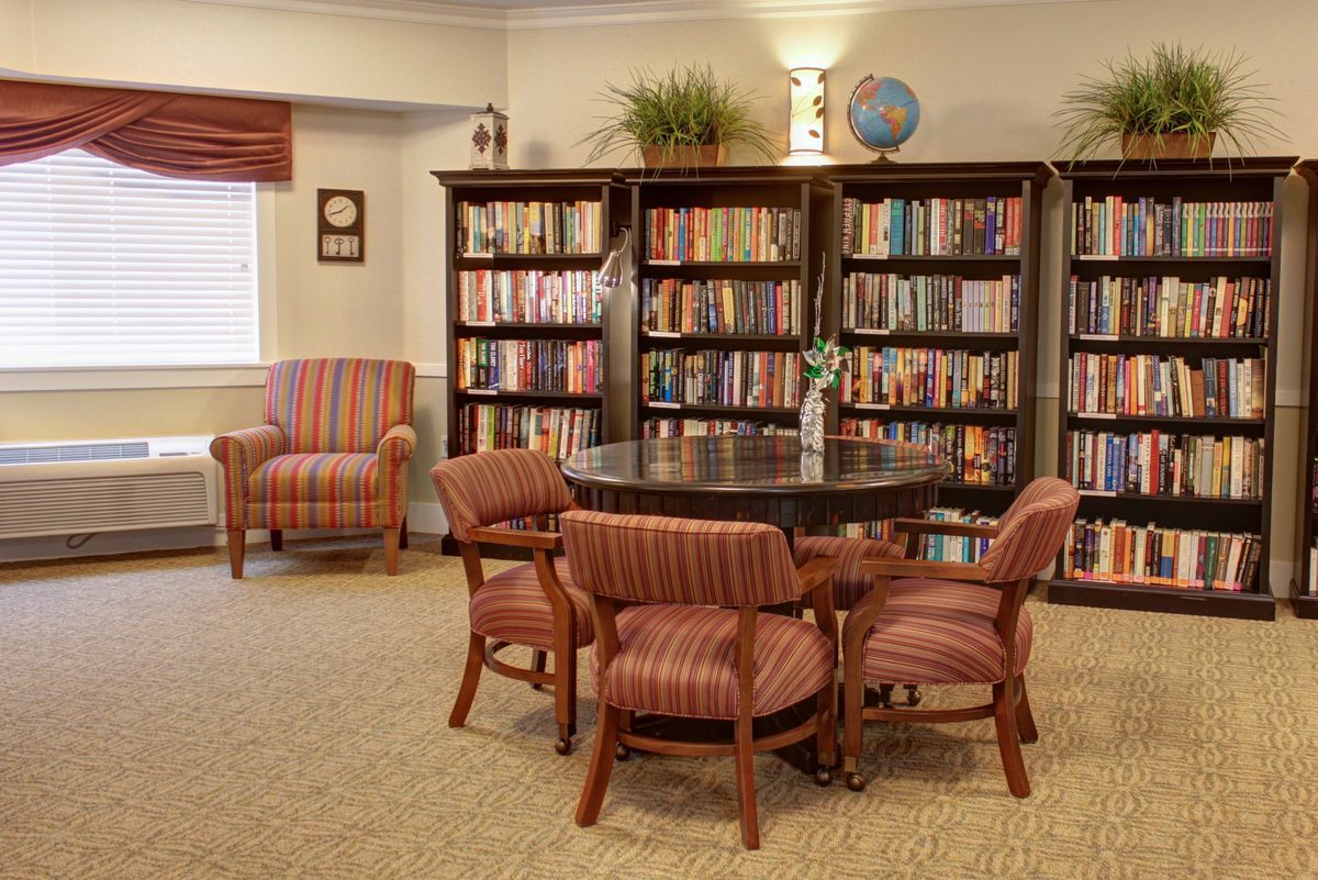 A cozy library reading area with bookshelves and comfortable seating.