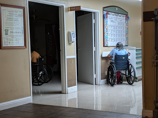 A view of a care facility with individuals in wheelchairs, showcasing an environment focused on accessibility and assistance.