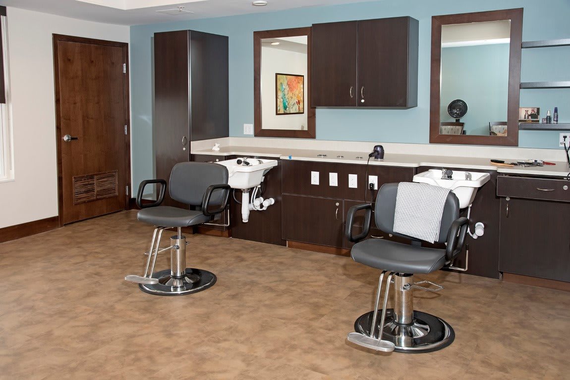 A modern barbershop interior with styling chairs and washbasins.