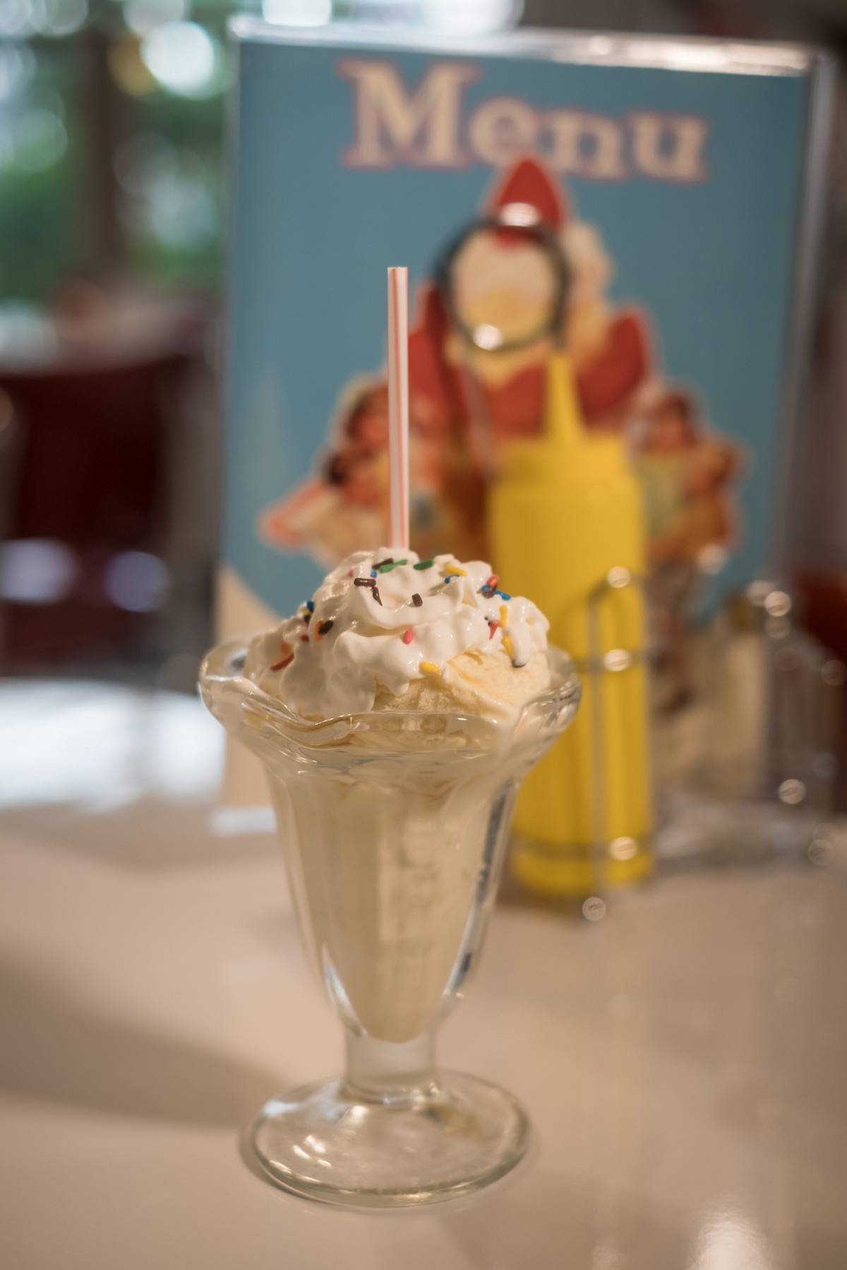 A delicious milkshake topped with whipped cream and colorful sprinkles.
