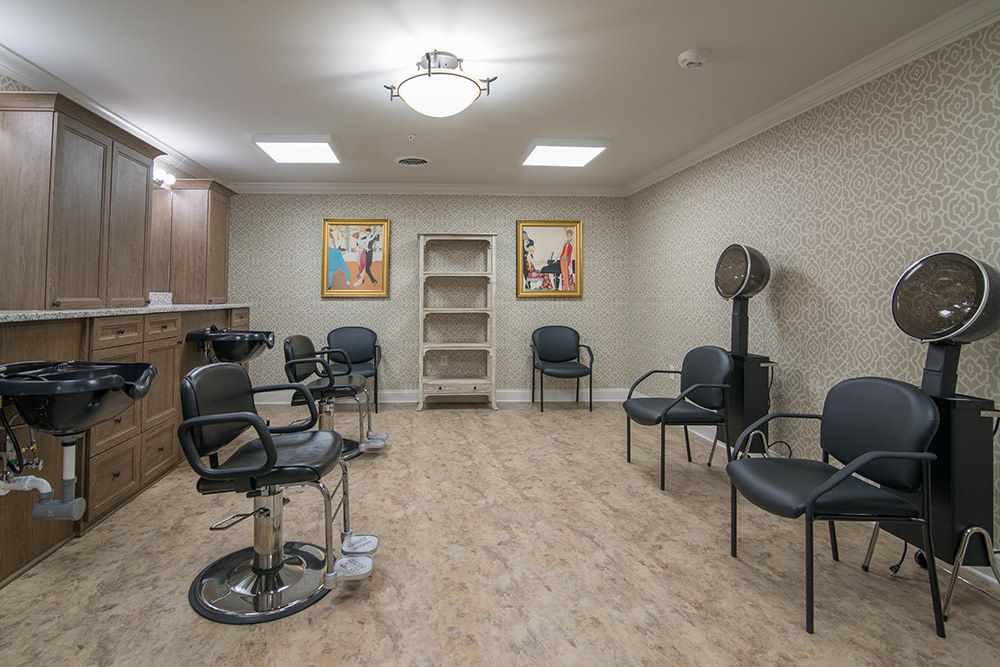 A cozy hair salon with styling chairs and a waiting area, featuring artwork on the walls.