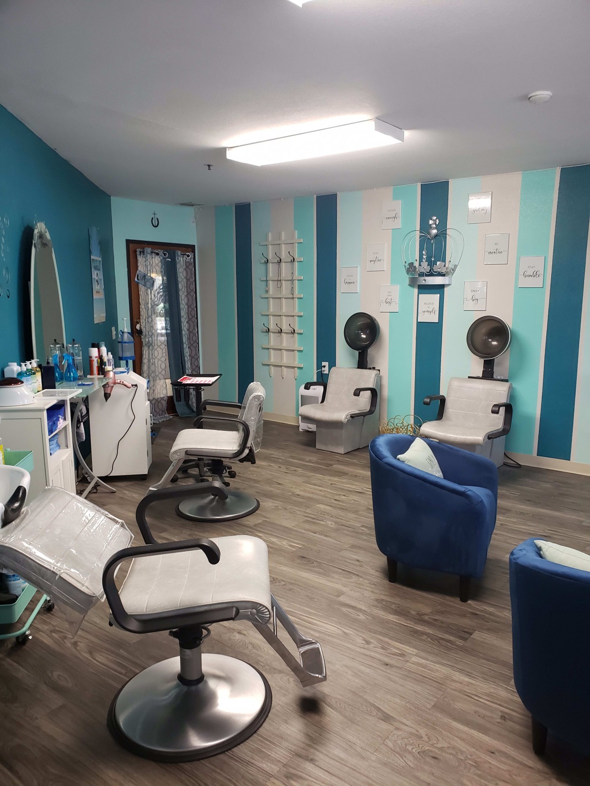 A modern beauty salon interior with styling chairs, mirrors, and hair dryers.
