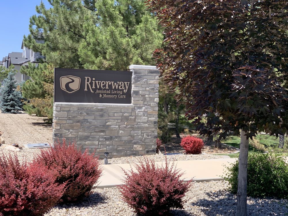 Entrance sign of Riversong community surrounded by landscaped shrubbery.
