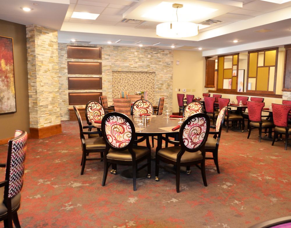 A stylish dining area with ornate chairs and a round table in an elegantly decorated room.