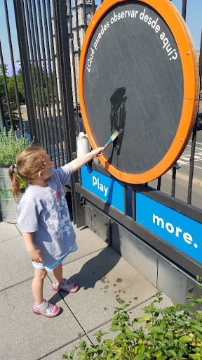 A child engaged in painting on an interactive art display.