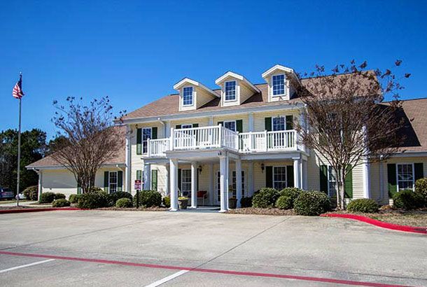 Two-story house with a balcony and driveway.