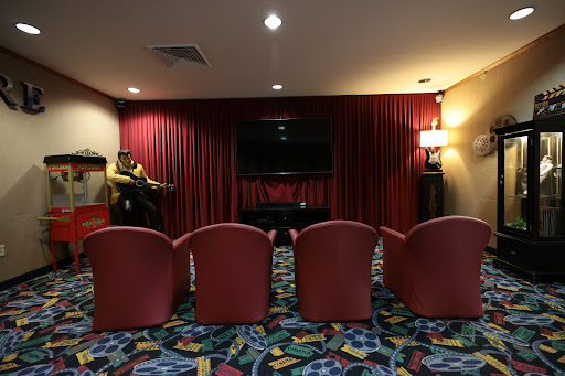 A cozy home theater setup with red chairs and a vibrant carpet.