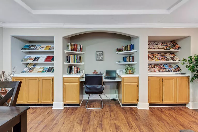 A cozy home office setup with bookshelves and a desk.