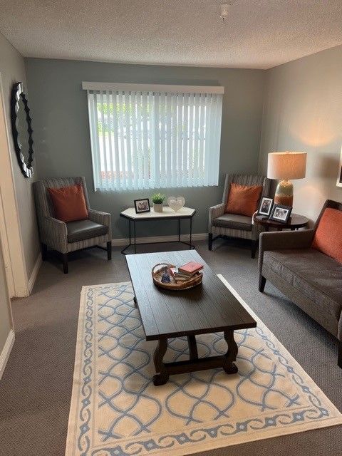 A cozy living room with comfortable armchairs, a coffee table, and warm lighting.