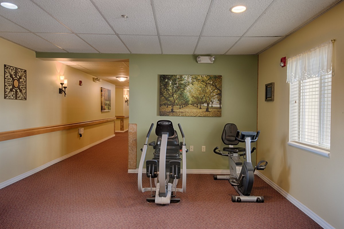 A small workout area in a hallway featuring exercise machines, including a stationary bike.