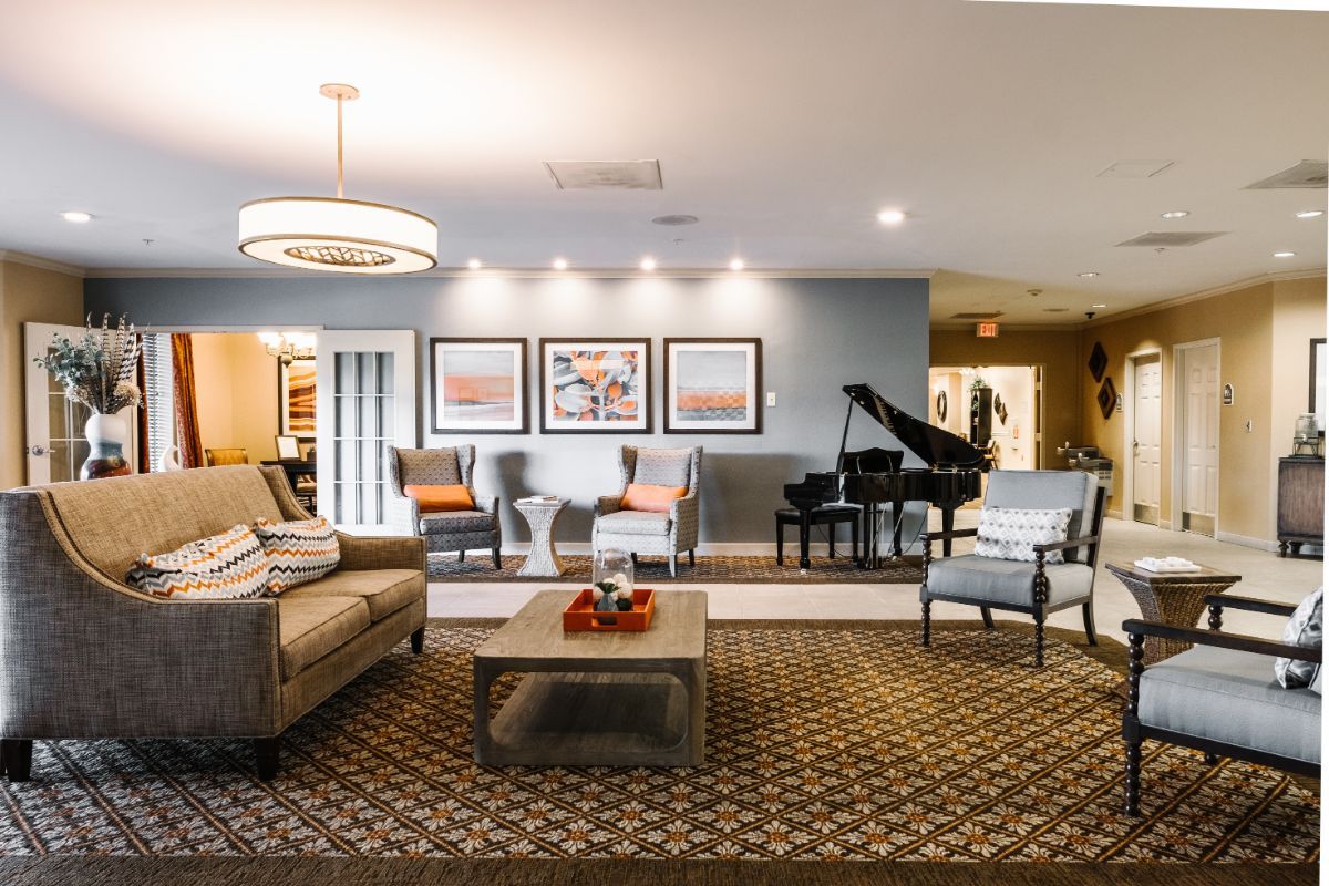 A cozy and elegantly designed living room featuring a comfortable seating arrangement, a grand piano, and stylish decor.