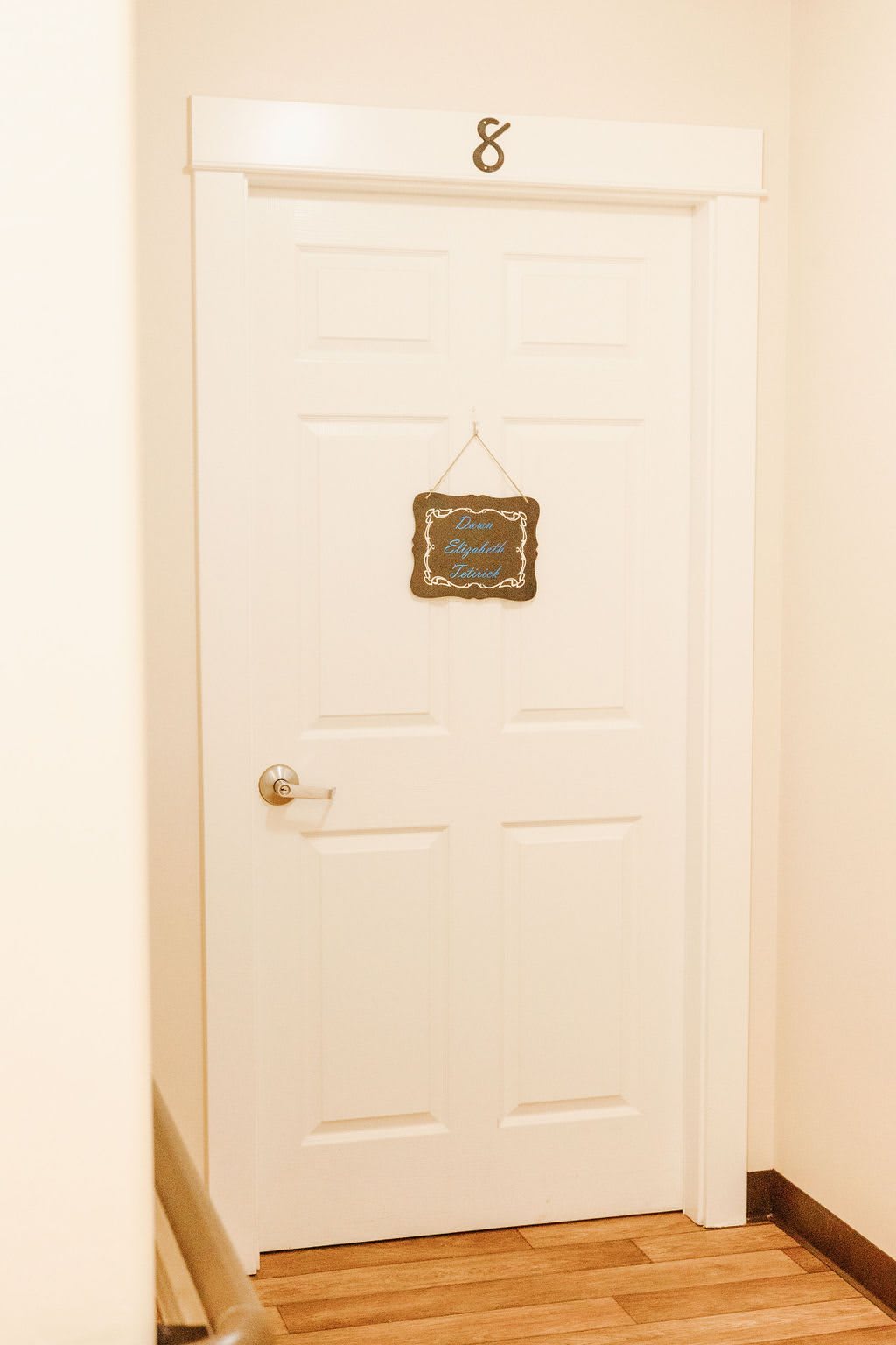 A closed white interior door with a small decorative sign hanging on it.