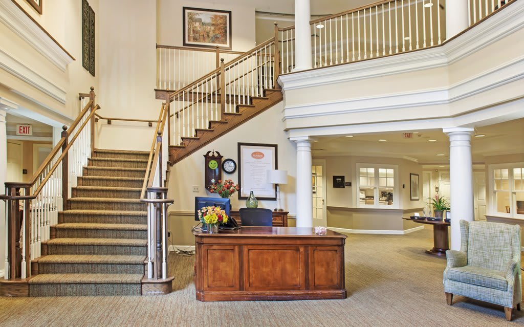 A welcoming reception area featuring a wooden desk and staircase.