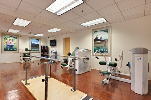 A well-equipped physical therapy room featuring various exercise machines and rehabilitation tools.