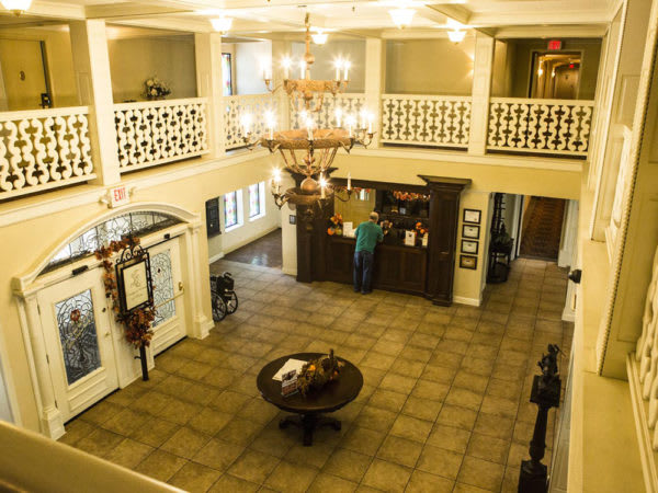 A spacious hotel lobby with a chandelier and reception desk.