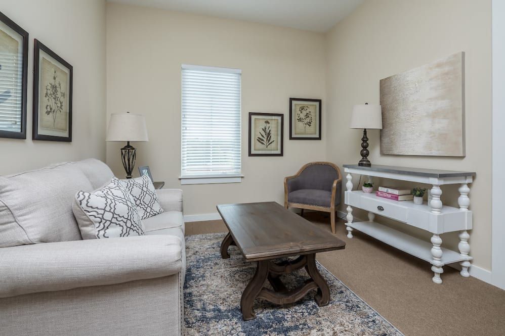 A cozy living room with a neutral color palette, featuring a sofa, coffee table, and decorative artwork.