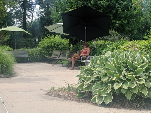 A person enjoying a peaceful moment in a park under an umbrella.