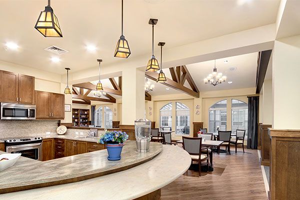 A spacious and modern kitchen and dining area featuring elegant lighting and wood flooring.
