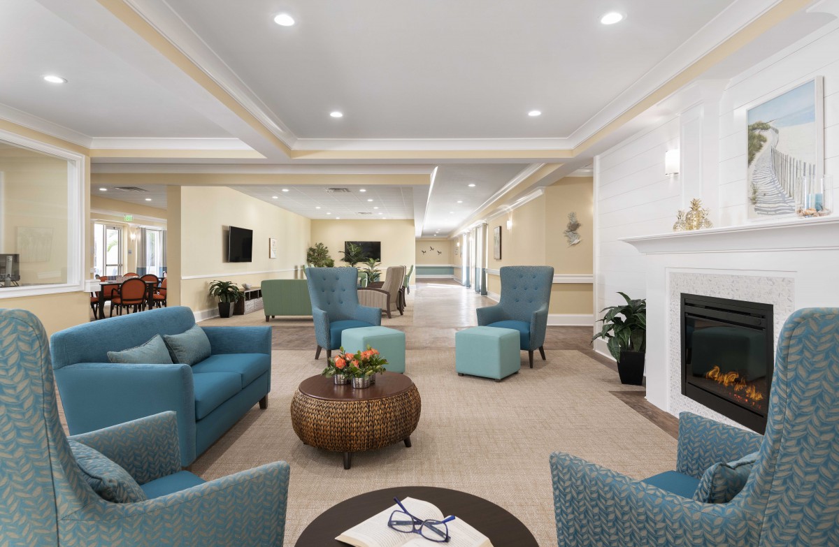 A spacious and elegantly designed living room with blue seating and a fireplace.