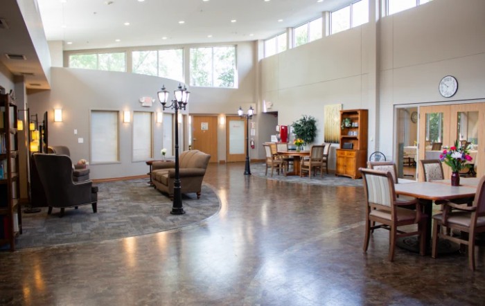 A spacious and well-lit living room with modern furniture and hardwood flooring.