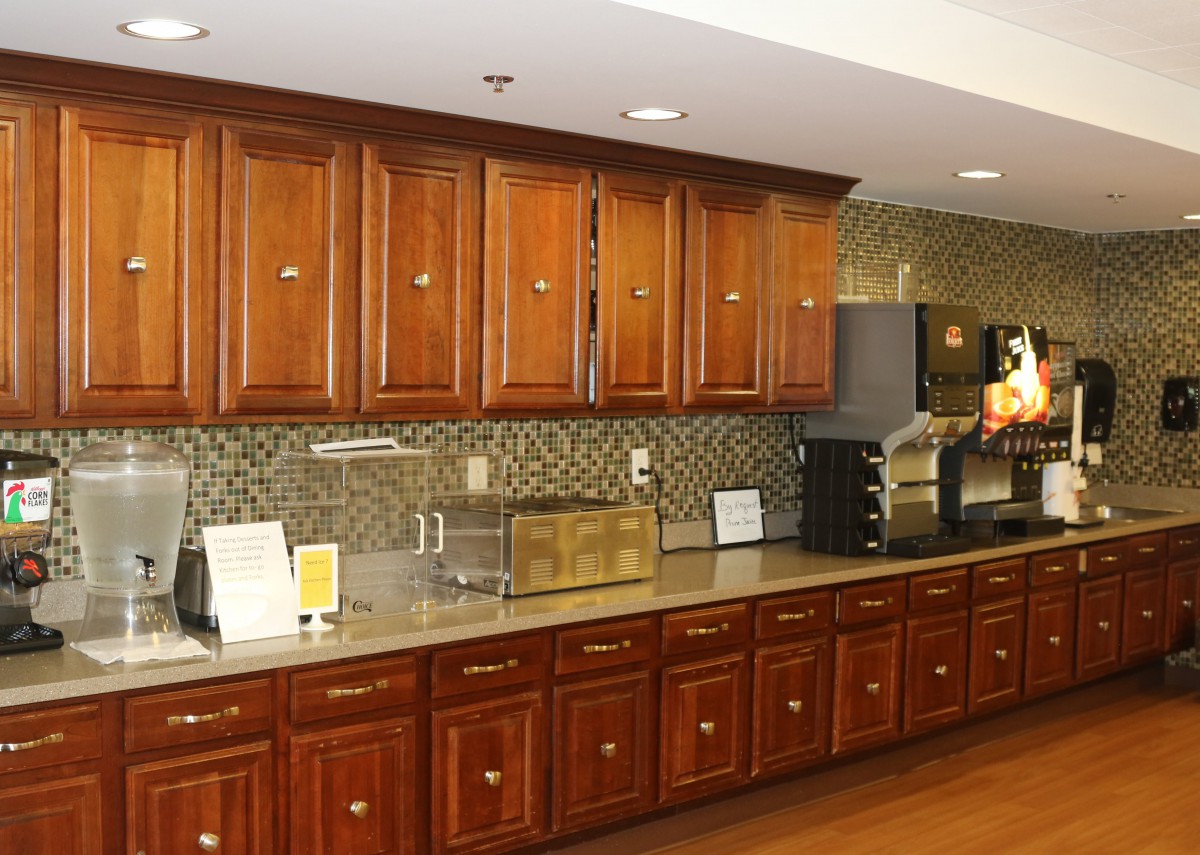 A modern kitchen with wooden cabinetry and various appliances.
