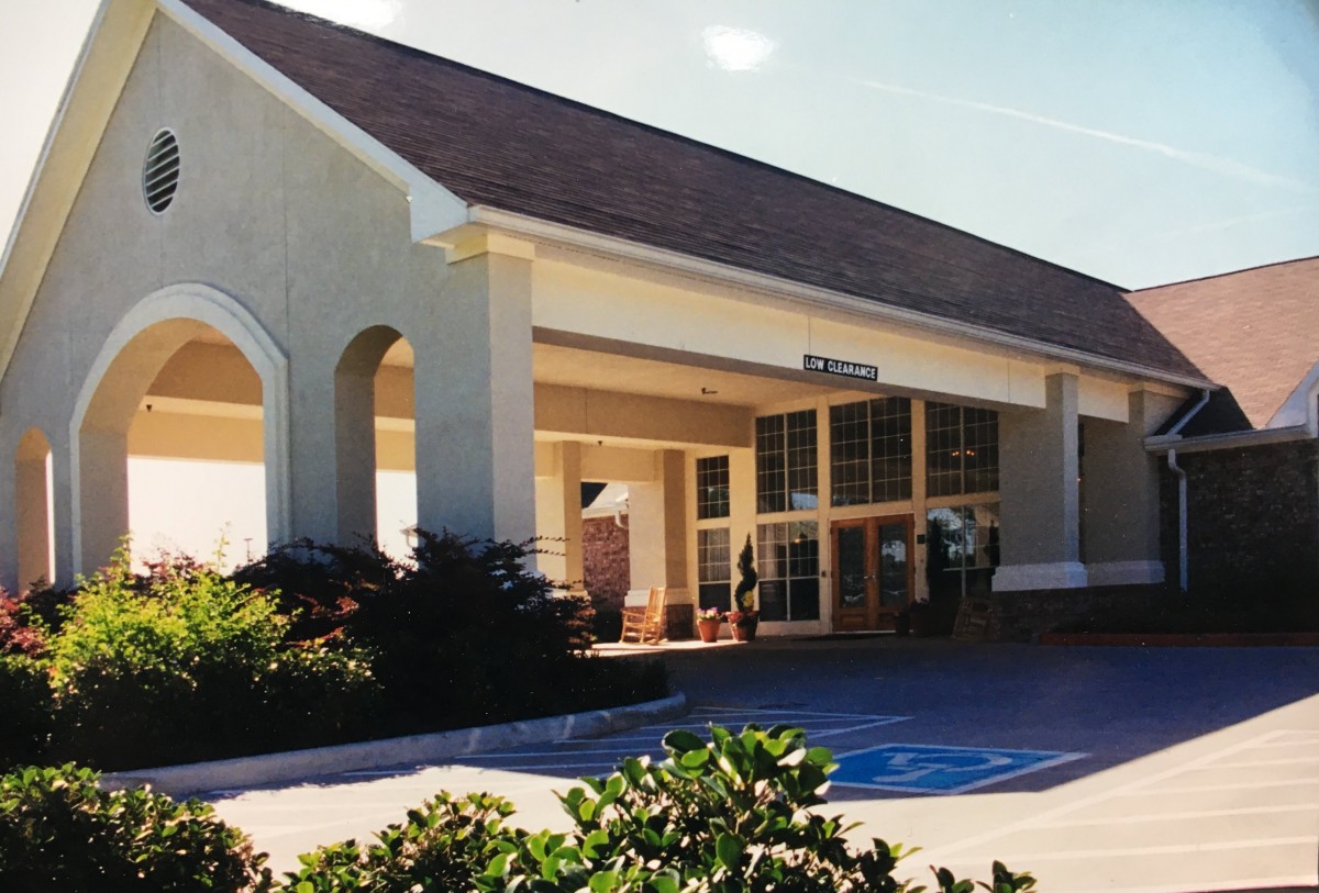 The exterior of a building with an entrance area and surrounding landscaping.