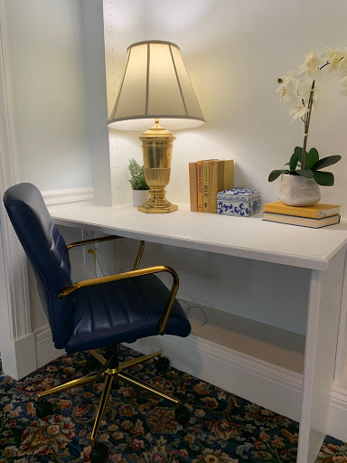 A cozy workspace featuring a sleek desk, comfortable chair, and a touch of greenery.