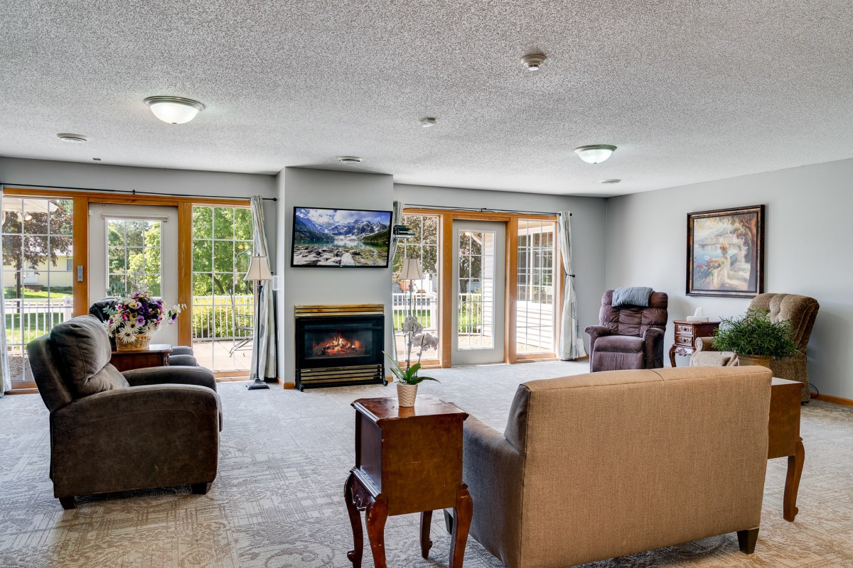 A spacious living room with a cozy fireplace and large windows.