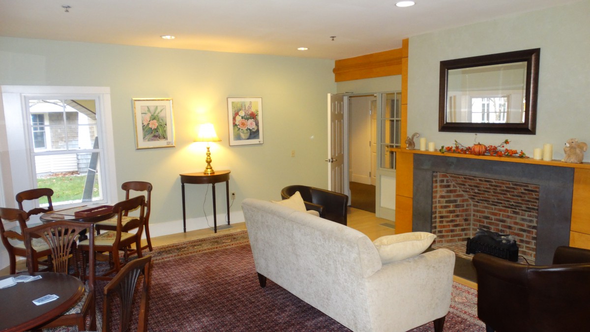 A cozy living room featuring a sofa, artwork on the walls, and a fireplace.