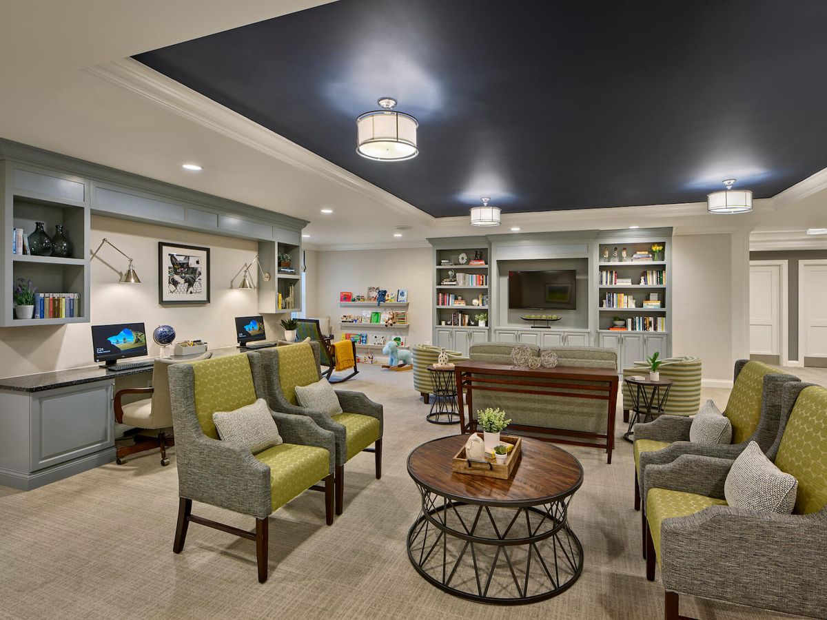 A cozy living room with modern furnishings, bookshelves, and comfortable seating.