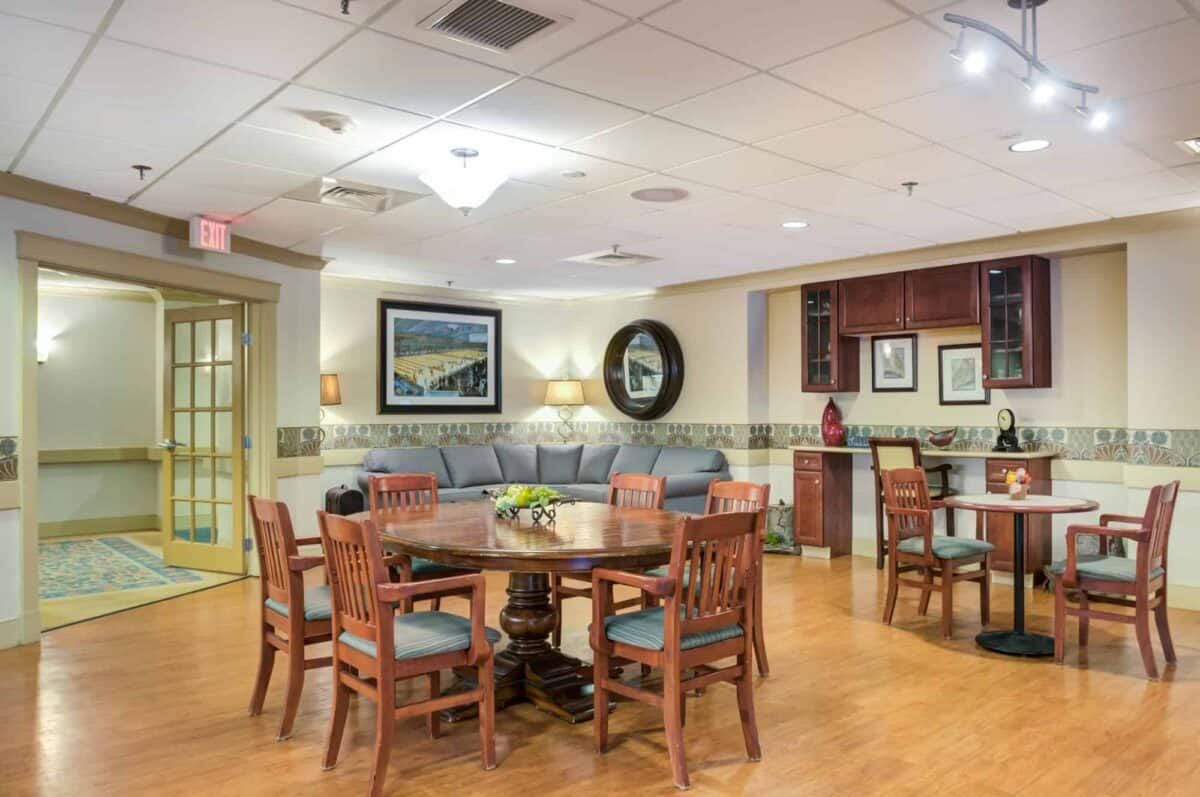 A cozy interior featuring a wooden dining set, comfortable sofa, and decorative artwork on the walls.