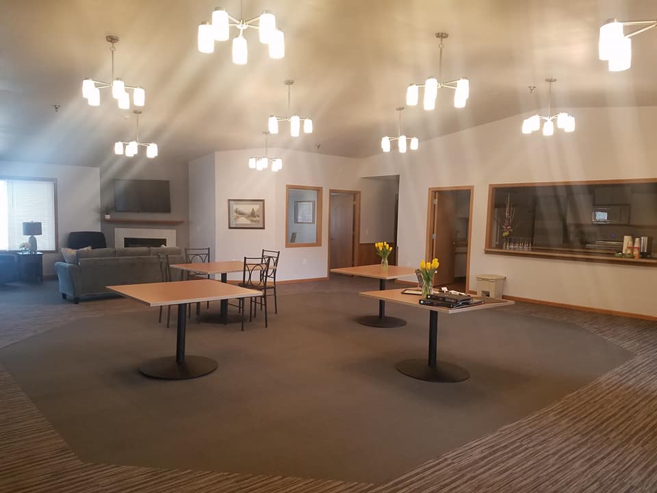 A spacious and modern dining room with tables, chairs, and elegant lighting.