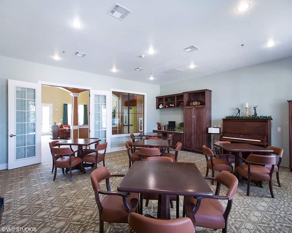 A spacious and well-lit dining area with wooden tables and chairs.