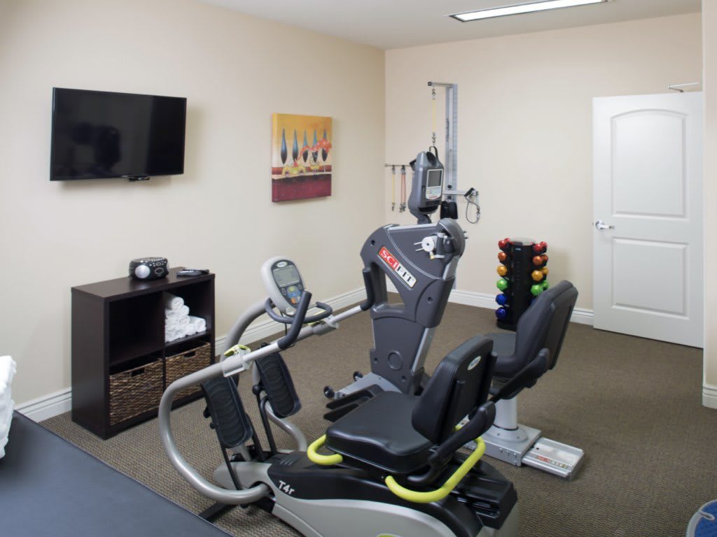 A fitness room featuring a cardio machine and weights.