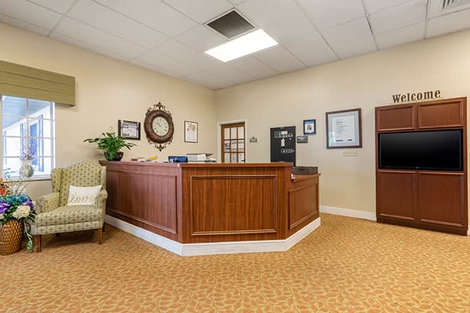 A welcoming reception area with a wooden desk and comfortable seating.